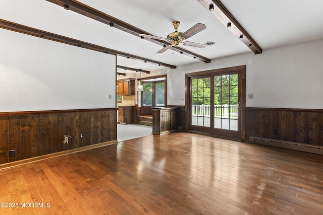 205 Edgemere Dr, Toms River, NJ 08755 - unfurnished living room featuring beam ceiling, a baseboard heating unit, wood walls, wood finished floors, and a wainscoted wall