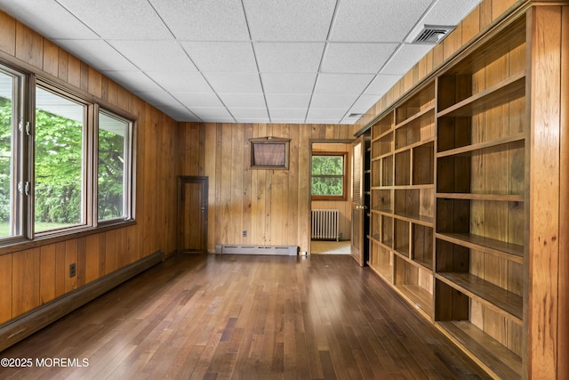 205 Edgemere Dr, Toms River, NJ 08755 - unfurnished living room with radiator, a baseboard heating unit, baseboard heating, dark wood-type flooring, and wooden walls