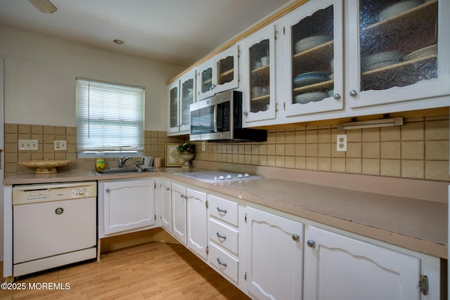30F Cambridge Ct, Lakewood, NJ 08701 - kitchen with white appliances, a sink, white cabinets, tasteful backsplash, and glass insert cabinets