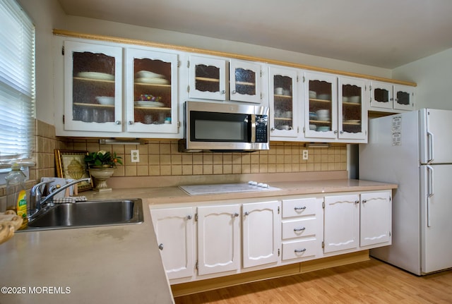 30F Cambridge Ct, Lakewood, NJ 08701 - kitchen featuring white appliances, a sink, light countertops, tasteful backsplash, and glass insert cabinets