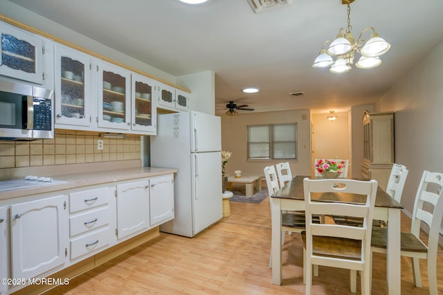 30F Cambridge Ct, Lakewood, NJ 08701 - kitchen featuring stainless steel microwave, freestanding refrigerator, decorative backsplash, glass insert cabinets, and light wood-style flooring