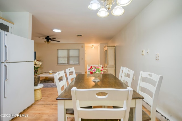 30F Cambridge Ct, Lakewood, NJ 08701 - dining area featuring light wood-type flooring, a baseboard heating unit, a chandelier, and ceiling fan