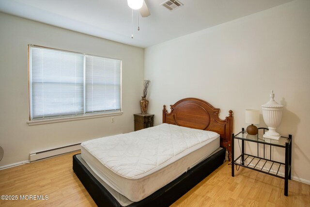 30F Cambridge Ct, Lakewood, NJ 08701 - bedroom with a baseboard heating unit, light wood finished floors, and baseboards