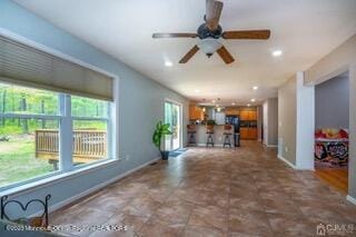 unfurnished living room featuring baseboards, ceiling fan, and recessed lighting