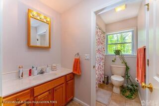 full bath with toilet, vanity, and tile patterned flooring