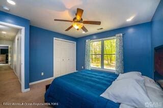 carpeted bedroom featuring a closet, baseboards, and ceiling fan