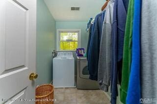 laundry room with washing machine and dryer and tile patterned flooring