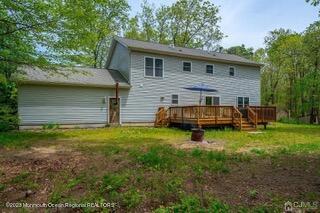 back of house with a wooden deck and a yard