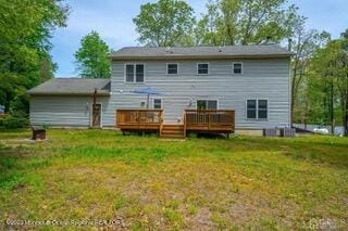 back of property with a deck and a yard