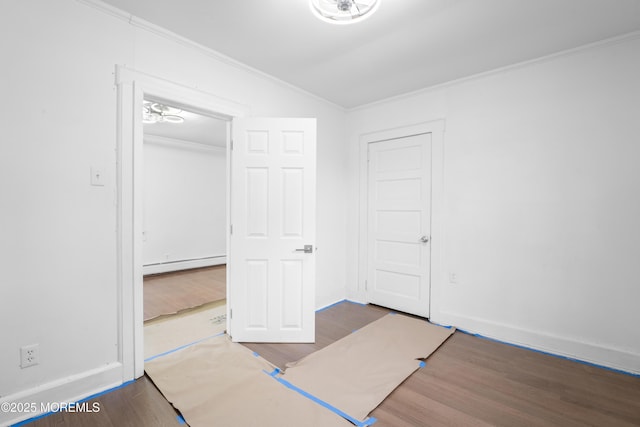 101 Forest Ave, Keansburg, NJ 07734 - unfurnished bedroom featuring baseboard heating, ornamental molding, wood finished floors, and baseboards