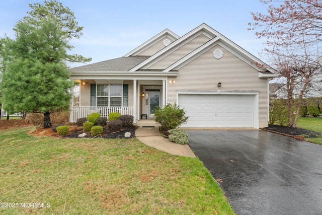 traditional-style house featuring driveway, covered porch, an attached garage, and a front lawn