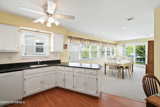 39 Patmore Rd, Brick, NJ 08724 - kitchen featuring white dishwasher, a sink, dark countertops, wood finished floors, and white cabinetry
