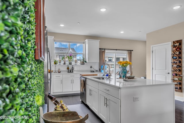 kitchen featuring a sink, stainless steel dishwasher, an island with sink, healthy amount of natural light, and recessed lighting