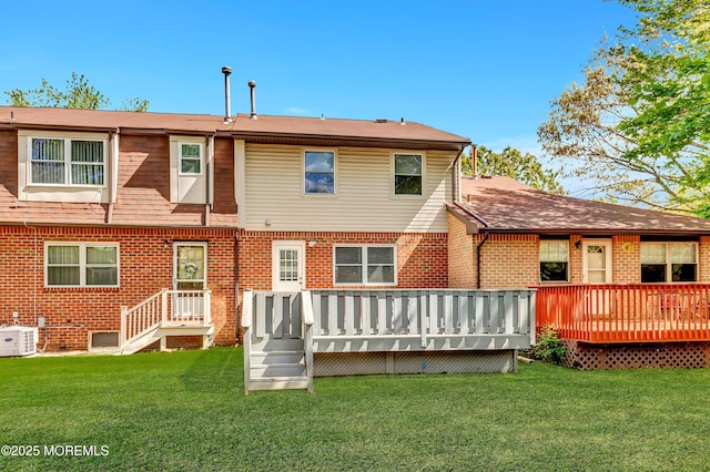 rear view of property featuring brick siding, central air condition unit, a yard, and a deck