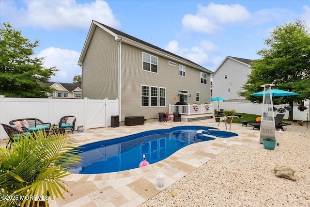 view of swimming pool with a wooden deck, a patio area, and a fenced backyard
