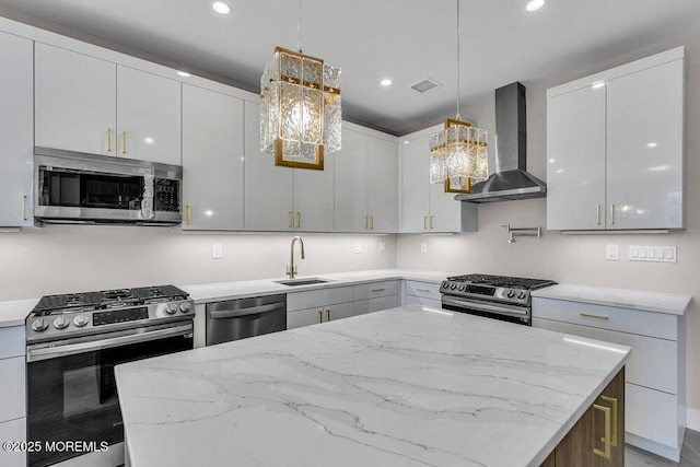14 Blue River Way, Lakewood, NJ 08701 - kitchen featuring appliances with stainless steel finishes, wall chimney range hood, a sink, a kitchen island, and light stone countertops