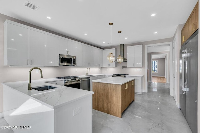 14 Blue River Way, Lakewood, NJ 08701 - kitchen featuring stainless steel appliances, wall chimney range hood, a sink, a center island, and light stone countertops