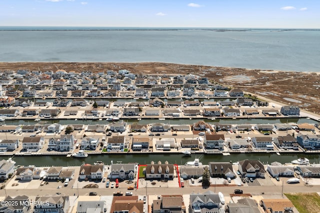 aerial view of property's location featuring a nearby body of water and nearby suburban area