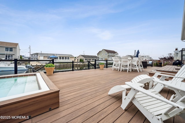 wooden terrace featuring a residential view and outdoor dining area