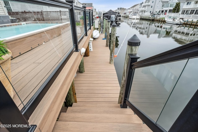 dock area with a water view, a residential view, and boat lift