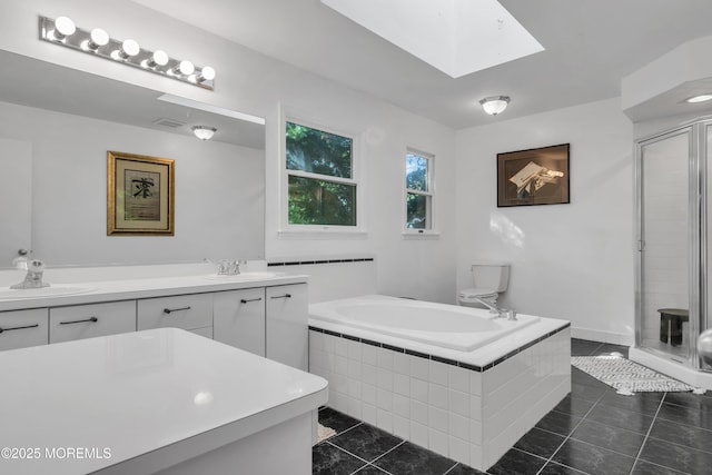 full bath featuring a skylight, a shower stall, a bath, and double vanity