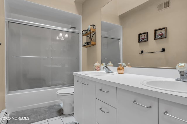 bathroom with a baseboard heating unit, tile patterned floors, double vanity, toilet, and bath / shower combo with glass door