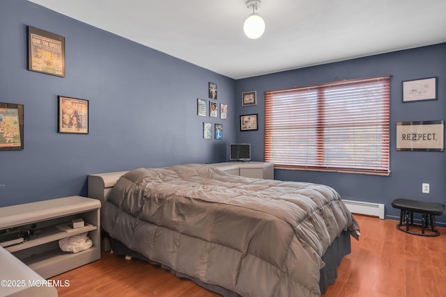 bedroom featuring a baseboard radiator and wood finished floors