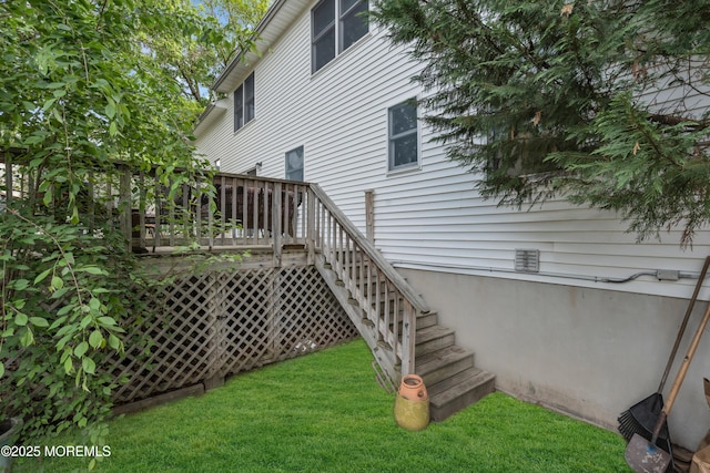 rear view of property featuring a yard, a wooden deck, and stairway