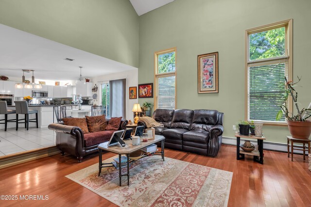 living room with high vaulted ceiling and light wood-style floors