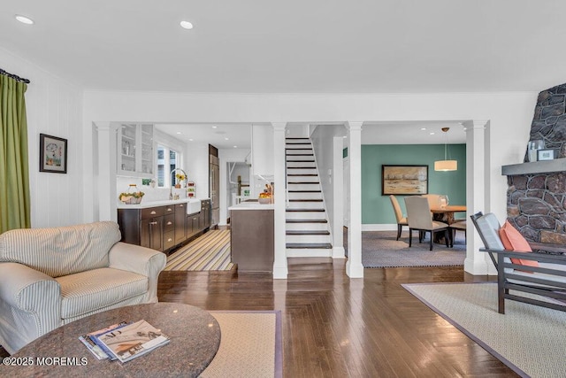 7 Sunset Dr, Asbury Park, NJ 07712 - living area featuring decorative columns, wood finished floors, baseboards, ornamental molding, and stairs