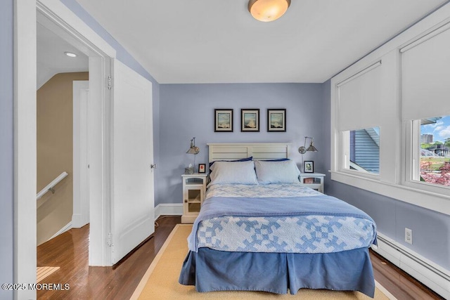 7 Sunset Dr, Asbury Park, NJ 07712 - bedroom featuring a baseboard heating unit, wood finished floors, and baseboards