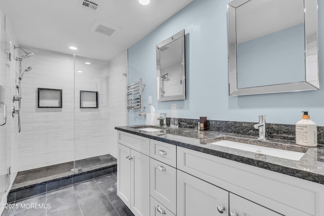 full bathroom featuring a stall shower, double vanity, tile patterned floors, and recessed lighting