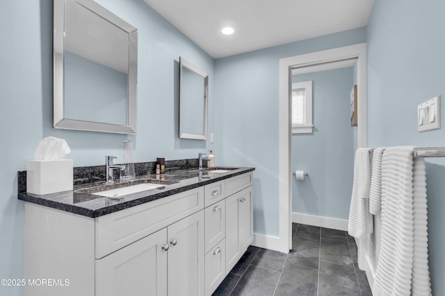 full bathroom with baseboards, double vanity, and tile patterned flooring