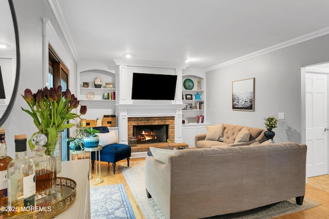 living room with ornamental molding, light wood-type flooring, a fireplace, and built in shelves
