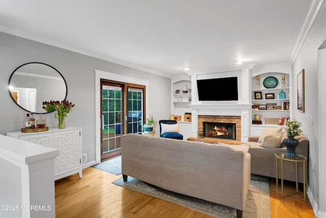 living room featuring a fireplace, light wood-type flooring, ornamental molding, built in features, and baseboards