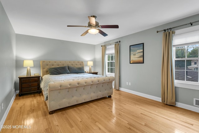 bedroom with light wood finished floors, baseboards, and ceiling fan