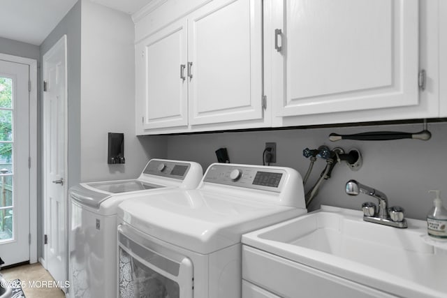 laundry room with washer and clothes dryer, cabinet space, and light tile patterned floors