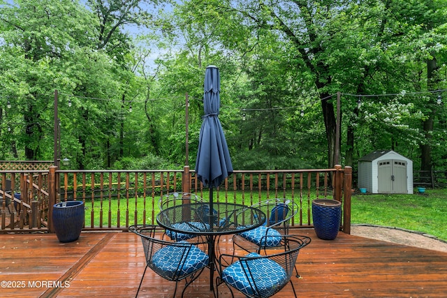 wooden deck featuring a shed, a yard, an outdoor structure, and outdoor dining space
