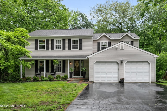 view of front of house featuring a garage, driveway, a porch, and a front lawn