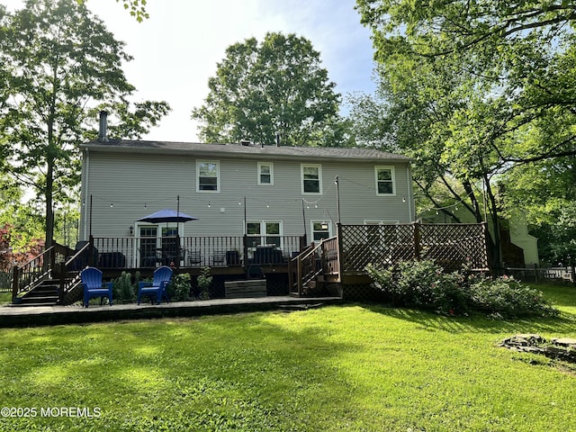 back of house with a wooden deck, a yard, and stairs
