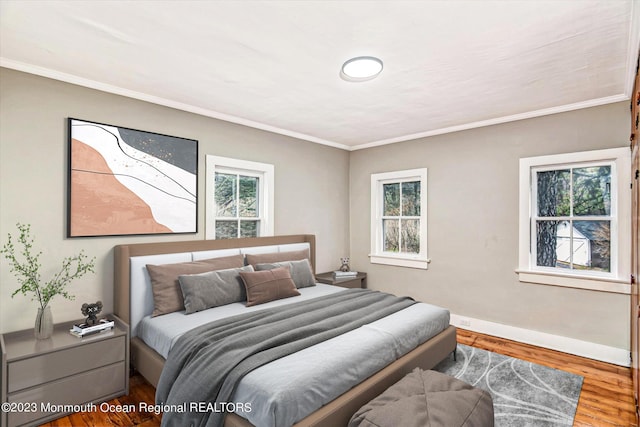 bedroom featuring wood finished floors, baseboards, and ornamental molding