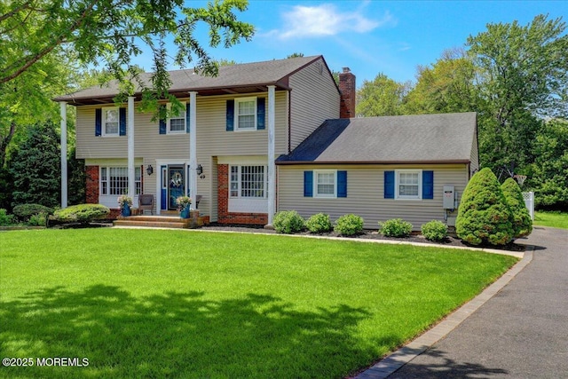 49 Glenbrook Rd, Freehold, NJ 07728 - view of front of house with a chimney, a front yard, and brick siding