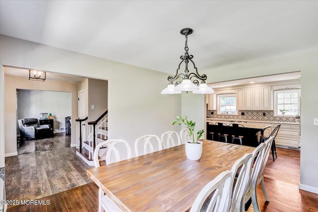 49 Glenbrook Rd, Freehold, NJ 07728 - dining room with stairway, a chandelier, dark wood-style flooring, and baseboards