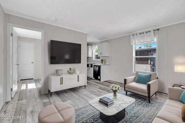 living room featuring light wood-type flooring and crown molding
