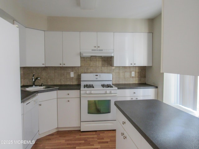 127 Meli Ln, Jackson, NJ 08527 - kitchen with white appliances, under cabinet range hood, a sink, dark countertops, and decorative backsplash