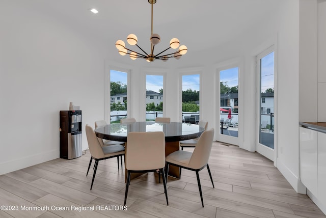 dining space featuring a chandelier, healthy amount of natural light, and light wood finished floors