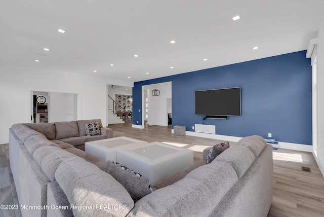 living area with stairway, wood finished floors, recessed lighting, and baseboards