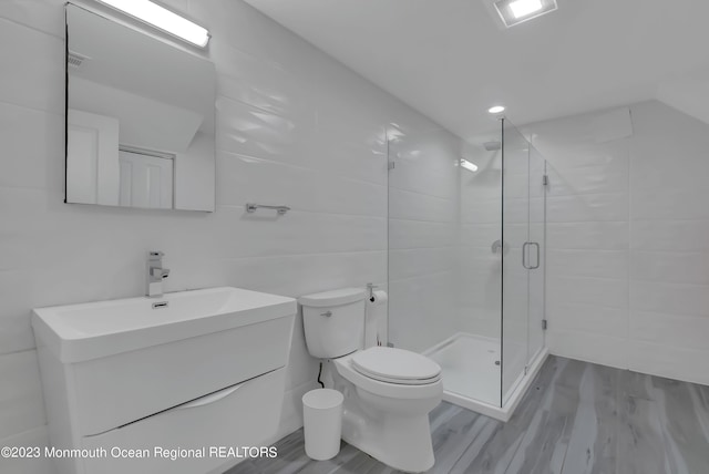full bathroom featuring vanity, a shower stall, wood finished floors, and toilet