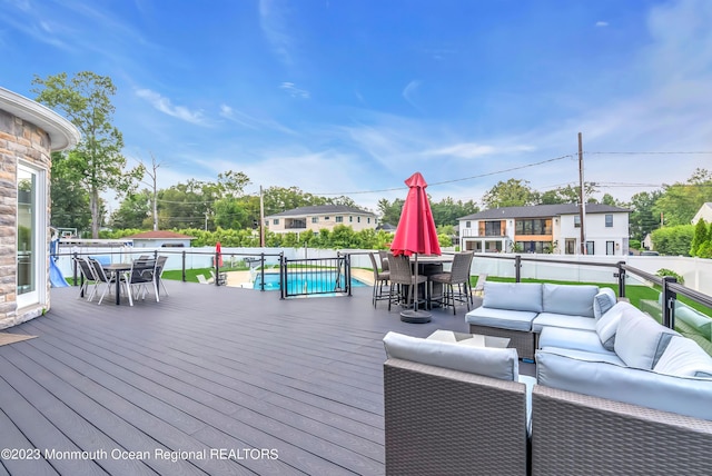 wooden terrace with outdoor dining space, outdoor lounge area, and fence