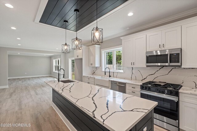 1808 2nd Ave, Toms River, NJ 08757 - kitchen with stainless steel appliances, an island with sink, white cabinetry, light stone countertops, and crown molding